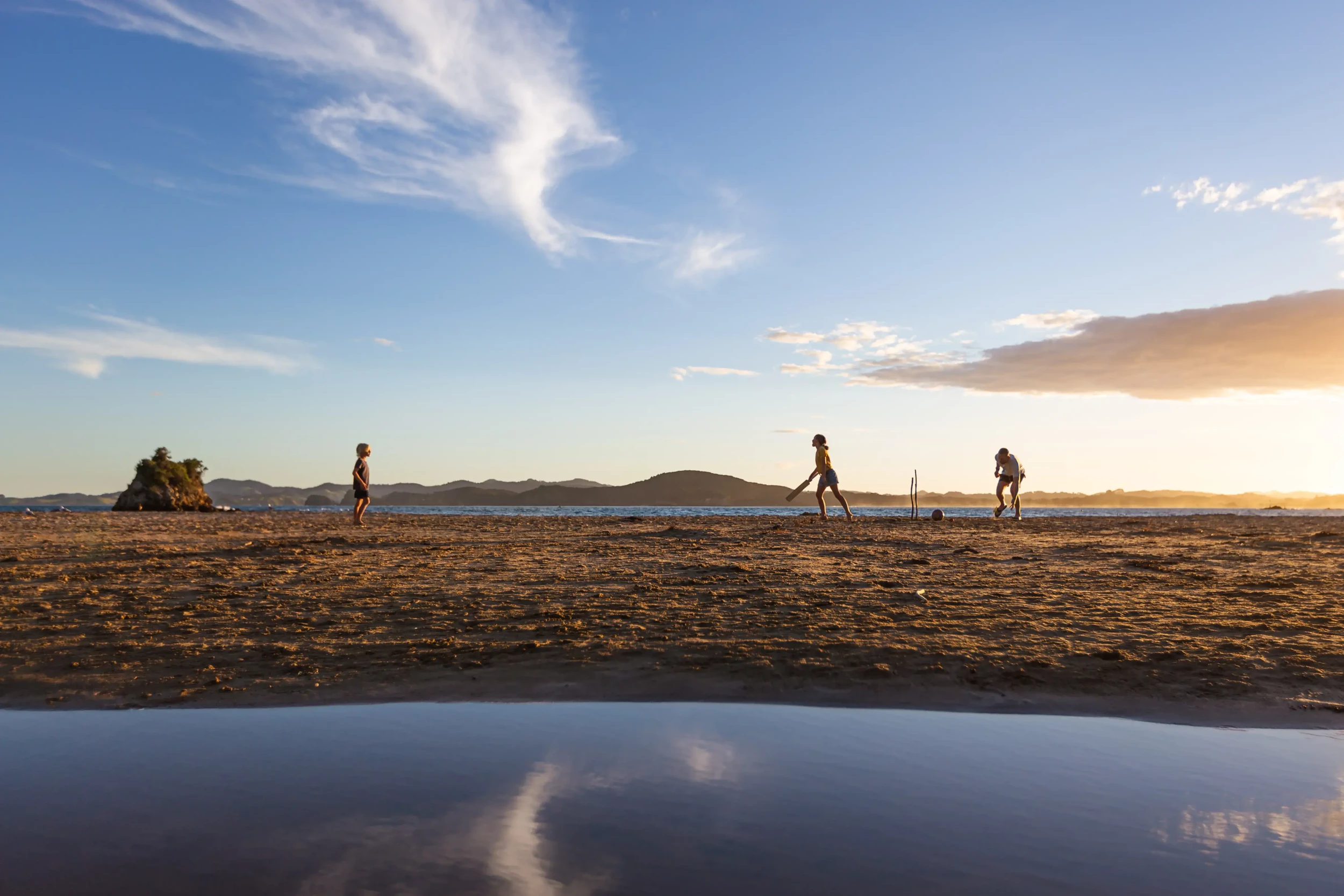 Beach cricket with friends in Northland