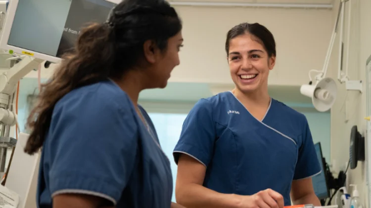 Registered Nurses Janita and Alyshia having a pleasant chat with Janita in the foreground on the left