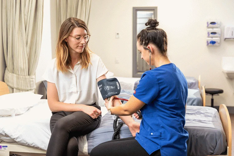 nurse with a patient assessing blood pressure