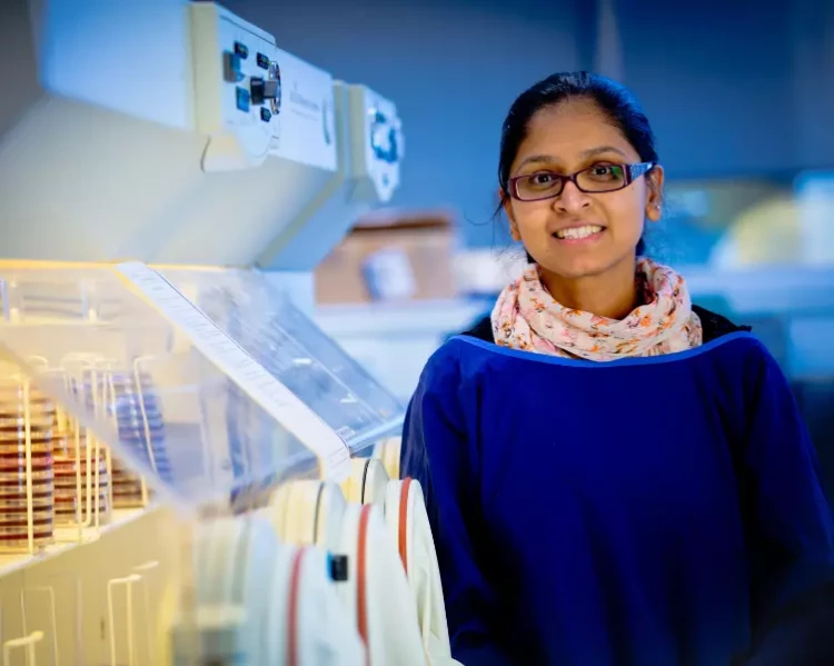 A pathologist standing next to some lab equipment in the hospital laboratory.